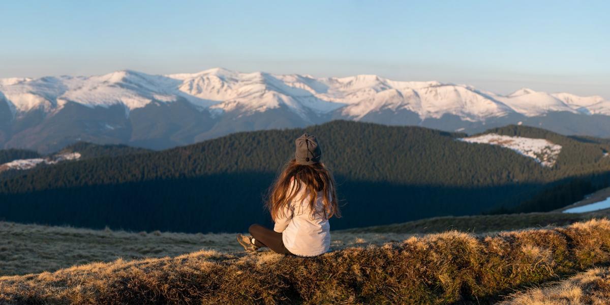 woman looking at hill behind mountains